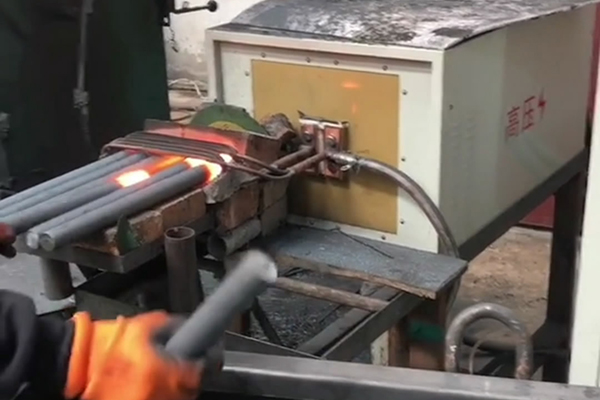 中頻鍛造加熱爐配自動送料系統(tǒng)對金屬棒材（如鐵棒、銅棒、鋁棒）的加熱和鍛造(圖1)